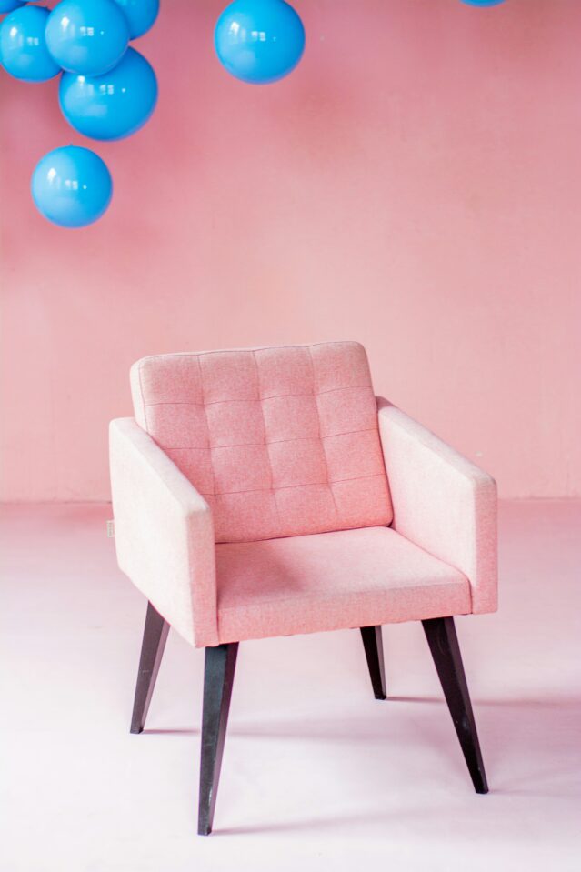 Bright pink sofa chair with blue balloons