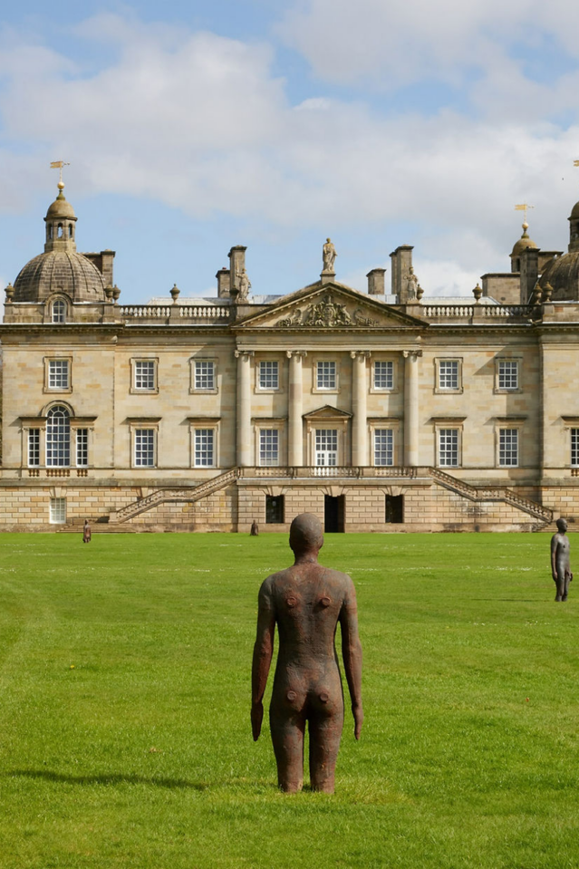 Antony Gormley statue in front of Houghton Hall in daylight