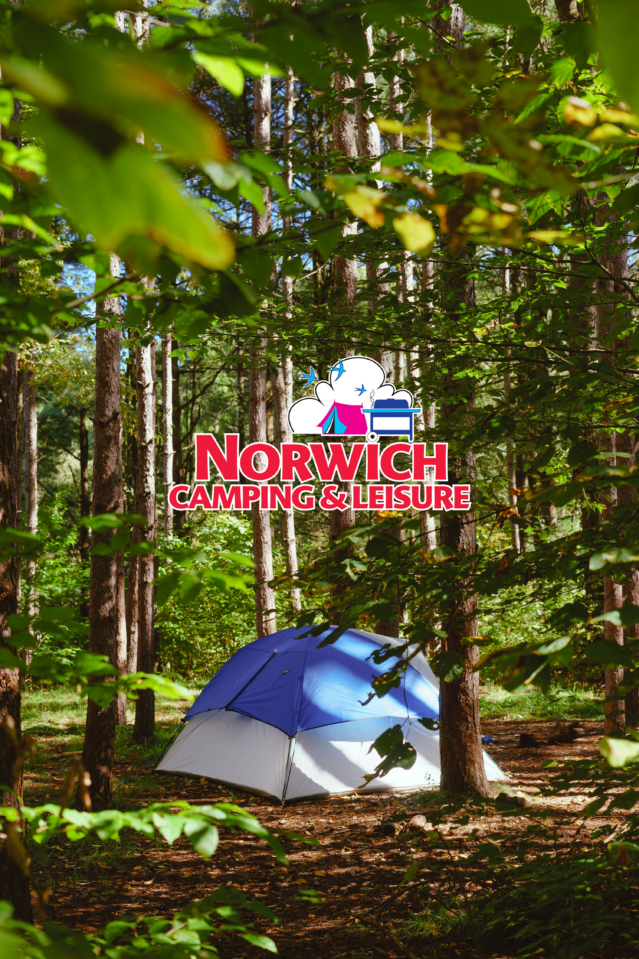 Blue tent in woods with Norwich Camping logo