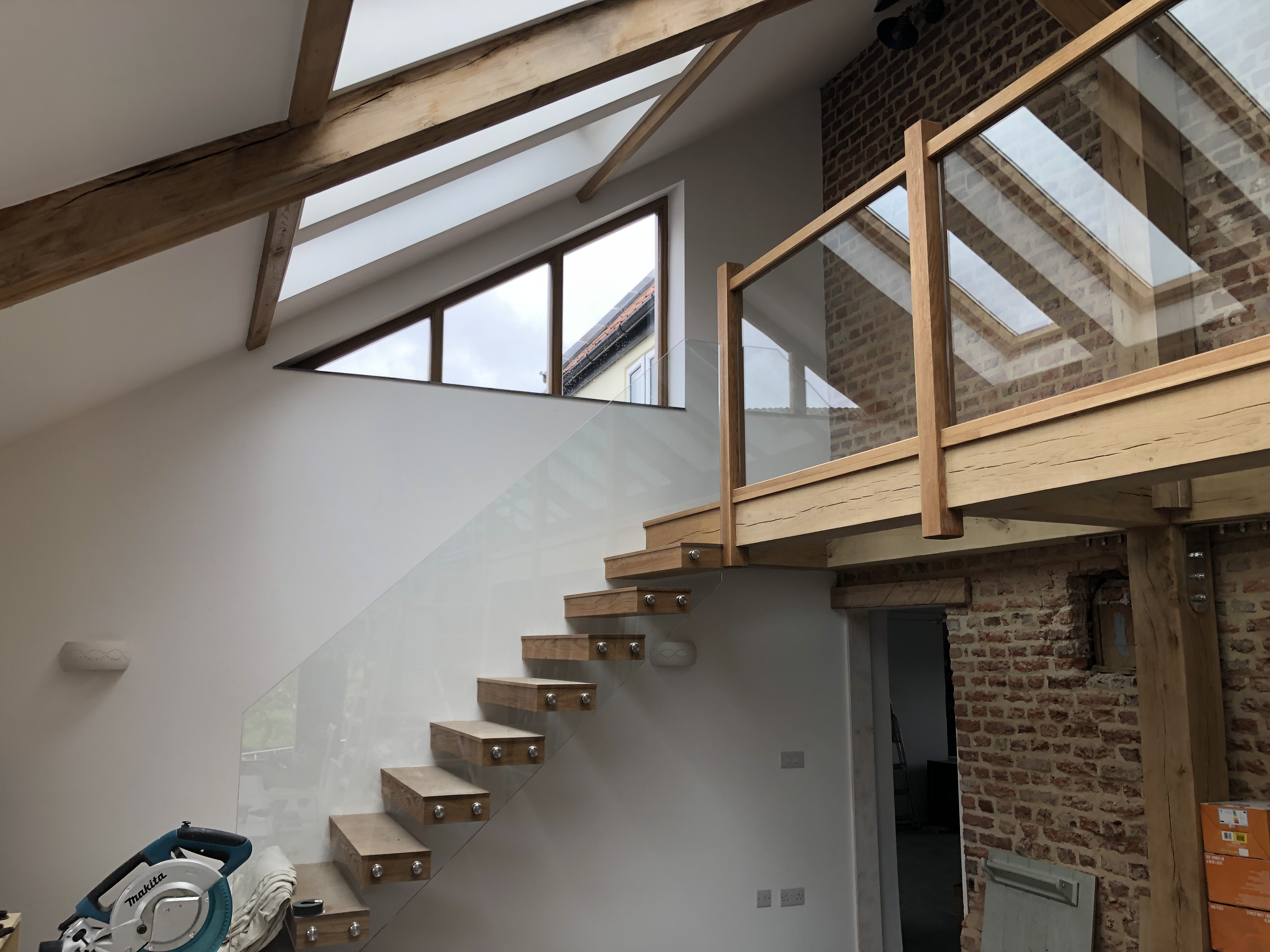 Photo of a wood and glass balcony and large skylight windows in tall ceiling